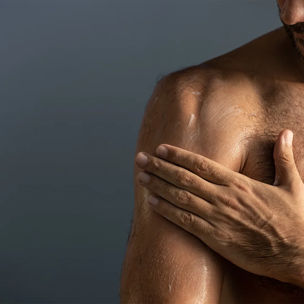 alva Naturkosmetik Model cremt sich alva For Him Körperlotion ein an der Schulter