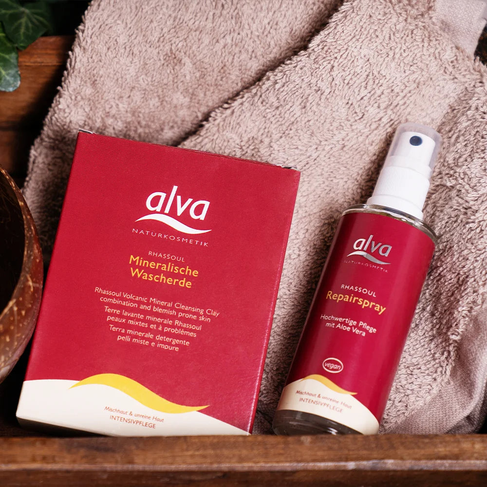 alva Rhassoul® Repairspray und alva Mineralische Tonerde liegen zusammen in Badezimmer Ablage.
