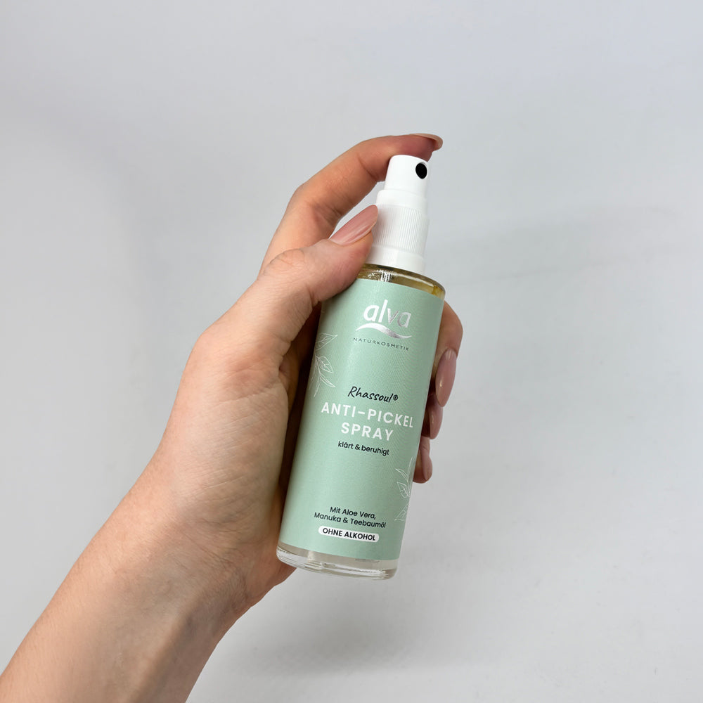 Rhassoul Anti-Pickel SPray wird in der Hand einer Frau gehalten