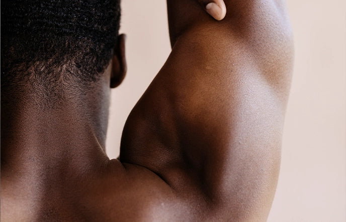 Farbiges, muskulöses, männliches Model hat den rechten Arm nach oben ausgestreckt. Es handelt sich um ein Close Up.