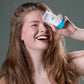 alva Model hat alva Kristall-Deo Stick sensitiv in Hand und lacht in die Kamera, close up.