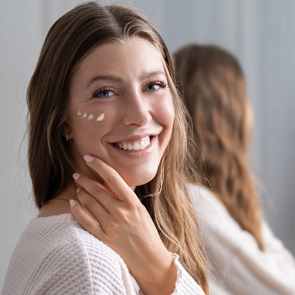 alva Naturkosmetik Model hat alva Sanddorn Feuchtigkeitscreme auf Wange aufgetragen und lacht in die Kamera.