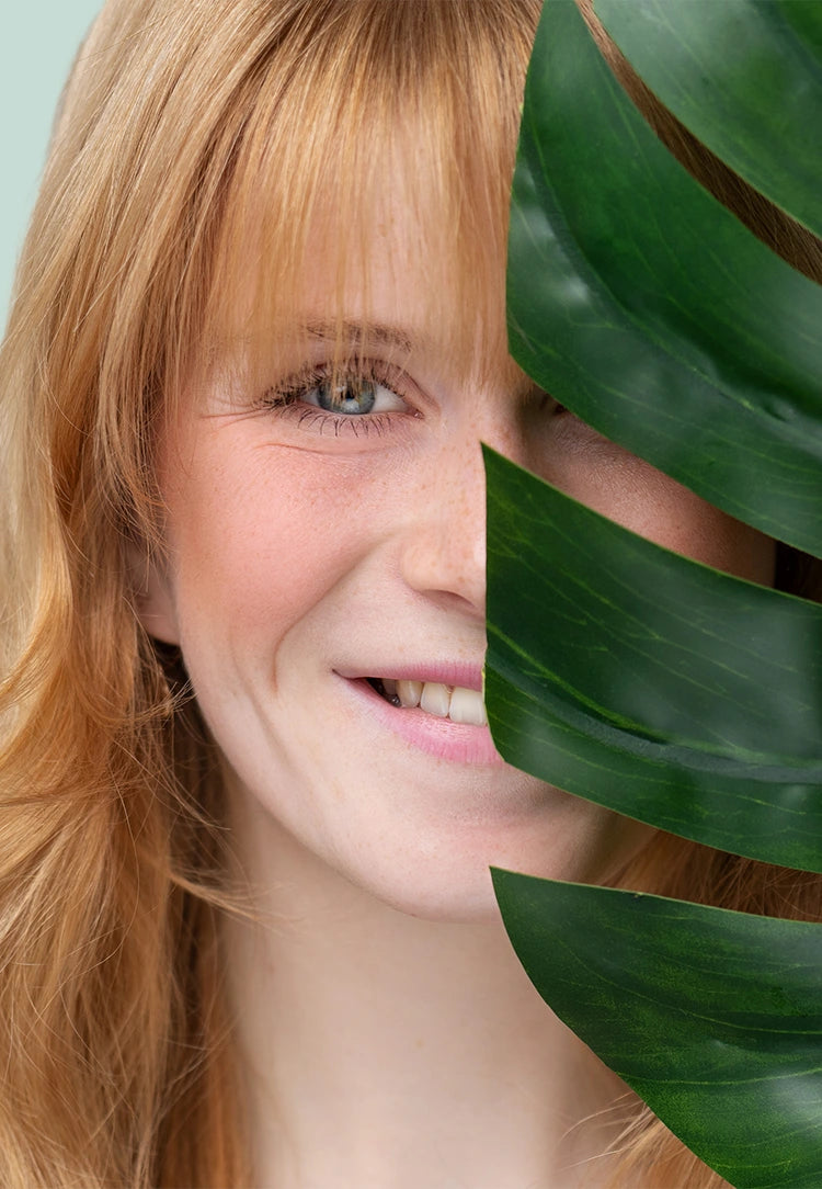 alva Naturkosmetik Model hat Blume im Gesicht und lächelt, mobiler Banner mit grünen Hintergrund.